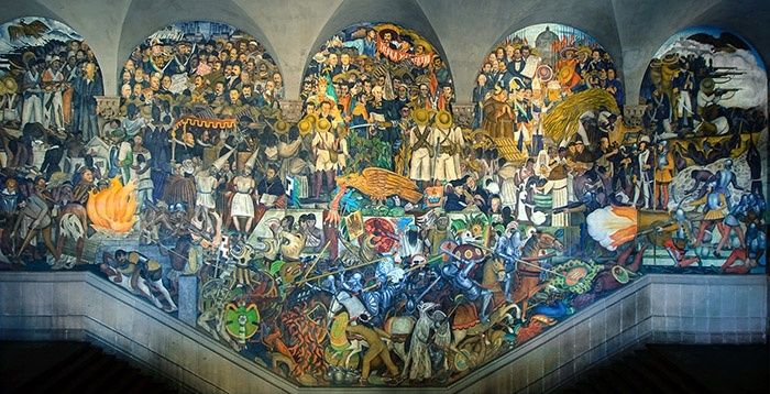 Large Mexican mural showing crowds, workers, conflict, and historical scenes